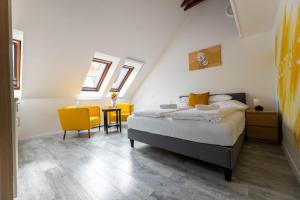 a bedroom with a bed and a yellow chair at Roomstore Studio Apartments in Eger