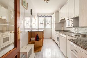 uma cozinha com armários brancos e uma bancada em Casa Julia playa de Berria em Santoña