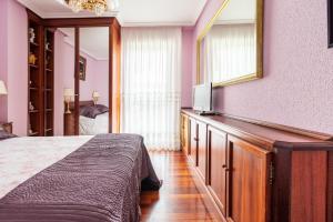 a bedroom with a large bed and a mirror at Casa Julia playa de Berria in Santoña