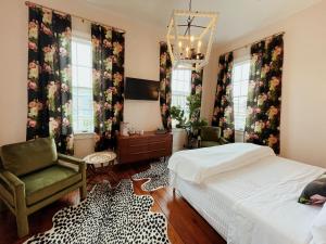 a bedroom with a bed and a chair and windows at Sugar's INN Room #6 King Bed in Galveston