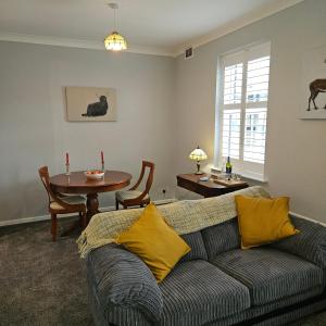 un soggiorno con divano e tavolo di Ground floor well appointed cosy flat in Ludlow a Ludlow