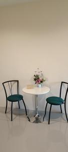 two chairs and a table with a vase of flowers at Family Pool View บ้านพักครอบครัวและสระว่ายน้ำ in Ban Bu Lao
