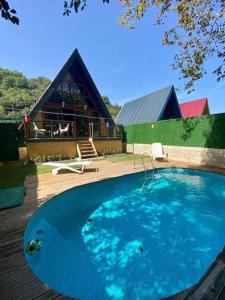 una grande piscina blu di fronte a una casa di Şile de Eşsiz Bungalov 2+1 Ev a Şile