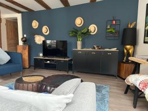 een woonkamer met een bank en een tv bij Le Schdorky in Colmar