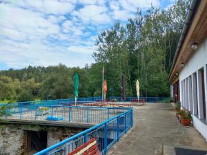 ein Gebäude mit einer Terrasse mit Bänken und Tischen in der Unterkunft Kemp na Staré papírně in Dobronice