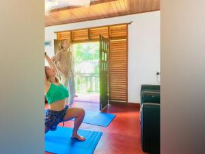 uma mulher a fazer uma pose de ioga num quarto em Vinu’s Place em Matara