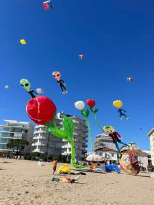 a bunch of kites flying in the sky on a beach at Hotel Terramare in Lido di Jesolo