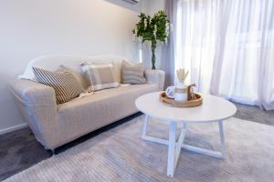 a living room with a couch and a table at Stylish 2-Bedroom Haven Next to Hagley Park in Christchurch