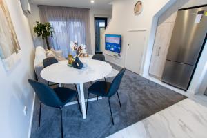 sala de estar con mesa blanca y sillas azules en Stylish 2-Bedroom Haven Next to Hagley Park en Christchurch