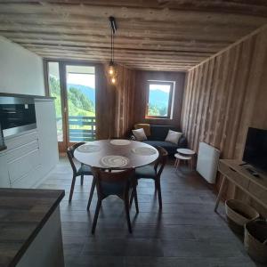 een woonkamer met een tafel en een bank bij Cocon familial au pied des pistes in Morillon