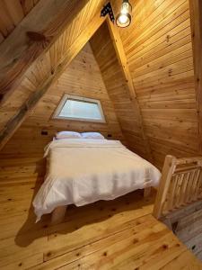 a bed in a wooden room with a window at Şile de Eşsiz Bungalov 2+1 Ev in Sile