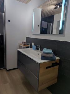ein Bad mit einem Waschbecken und einem Spiegel in der Unterkunft Kleine Auszeit - 2-Zimmer Ferienwohnung in Spiez