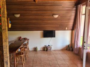 a dining room with a table and a tv in a house at Casa El Jardín in Piedras