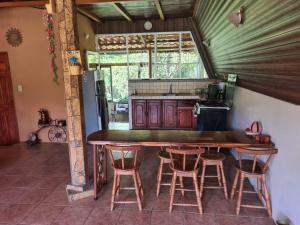 Piedras的住宿－Casa El Jardín，厨房配有一张大木桌和凳子