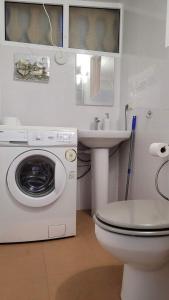 y baño con lavadora y lavamanos. en Villa Lenia, en Torrevieja