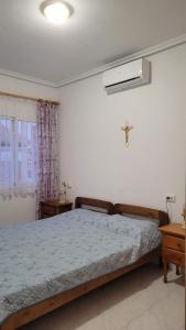 um quarto com uma cama e uma cruz na parede em Villa Lenia em Torrevieja