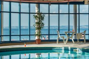 a swimming pool with a view of the ocean from a building at Les Résidences d'Armor Ternélia Hôtel-Résidence in Douarnenez