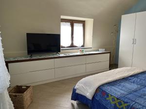 1 dormitorio con TV de pantalla plana en una cómoda en Casale Mariscoli B&B, en Cava deʼ Tirreni