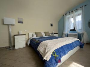 1 dormitorio con 1 cama con edredón azul y blanco en Casale Mariscoli B&B, en Cava deʼ Tirreni