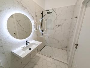 uma casa de banho branca com um lavatório e um espelho em Kyiv Honchara Hotel em Kiev