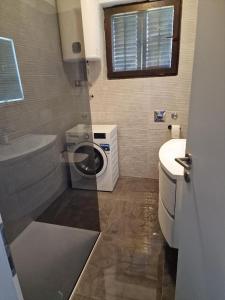 a bathroom with a washing machine and a sink at Apartman Ana in Draga Bašćanska