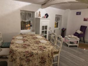 ein Esszimmer mit einem Tisch und einem floralen Tischtuch in der Unterkunft Le Nid du bois d'Oingt 