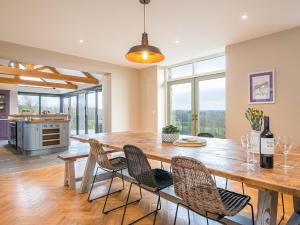 Il comprend une cuisine et une salle à manger avec une table et des chaises en bois. dans l'établissement Trecift, à Cardigan