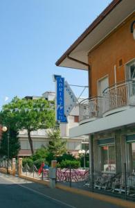 een gebouw met een blauw bord aan de zijkant bij Hotel Adriatico in Bellaria-Igea Marina