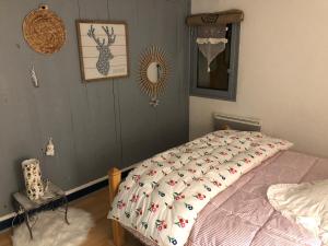 ein Schlafzimmer mit einem Bett mit einer Decke mit Vögeln darauf in der Unterkunft Le Nid du bois d'Oingt 