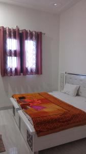 a bedroom with a bed in a room with windows at Gopi Dham Hotel in Vrindāvan