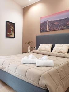 1 dormitorio con 1 cama grande y toallas. en Residence Cortile Mercè, en Trapani