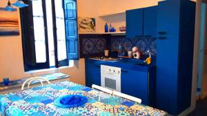 a kitchen with blue cabinets and a table with a plate on it at Esclusiva in Favignana