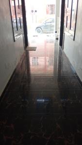 an empty hallway with a reflection of a building at Gopi Dham Hotel in Vrindāvan