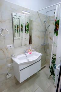 a white bathroom with a sink and a shower at Brothers LR in Sarandë +66 photos
