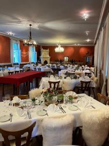 uma grande sala de jantar com mesas e cadeiras brancas em Badischer Landgasthof Hirsch em Hügelsheim