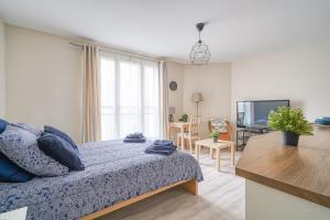 a bedroom with a bed and a living room at Logement Noah in Courcouronnes