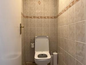 a small bathroom with a toilet and a tiled wall at 2-bedroom Flat in Regents Park-Euston-Camden in London +20 photos