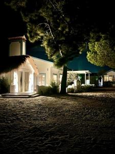 Una casa blanca con un árbol delante. en Casa Paloma, en Comporta