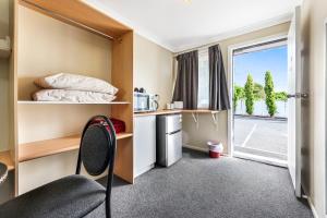 a room with a bed and a desk and a chair at Tamworth Lodge Motel in Tamworth