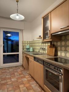 eine Küche mit Küchengeräten aus Edelstahl und einem großen Fenster in der Unterkunft Am Fuße zur Napoleonschanze in Hohnstein