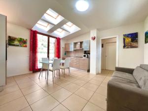 a living room with a couch and a table and chairs at Apartment GardaBeBo in Nago-Torbole
