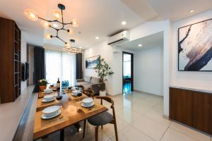 a dining room and living room with a table and chairs at S Lux Apartment in Ho Chi Minh City