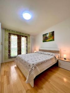 een slaapkamer met een groot bed en twee ramen bij Apartment GardaBeBo in Nago-Torbole