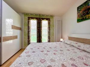 een slaapkamer met een bed en twee ramen bij Apartment GardaBeBo in Nago-Torbole