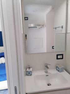 a white bathroom with a sink and a mirror at Donna Rosalia in Amalfi