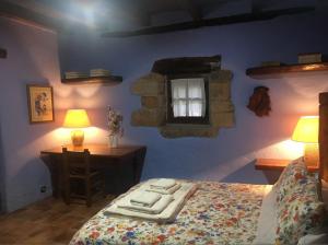 una camera con letto, scrivania e finestra di Precioso caserío con jardín a Bakio