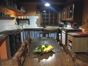 una cucina con tavolo in legno e ciotola di frutta di Precioso caserío con jardín a Bakio