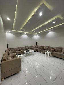 a living room with couches and tables in a room at استراحة عمر in Hail