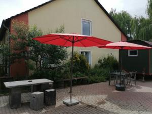 two red umbrellas in front of a building at Hasthaushof in Breitscheid
