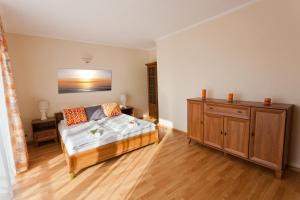 a living room with a bed and a wooden cabinet at Apartament Słoneczny in Ustka